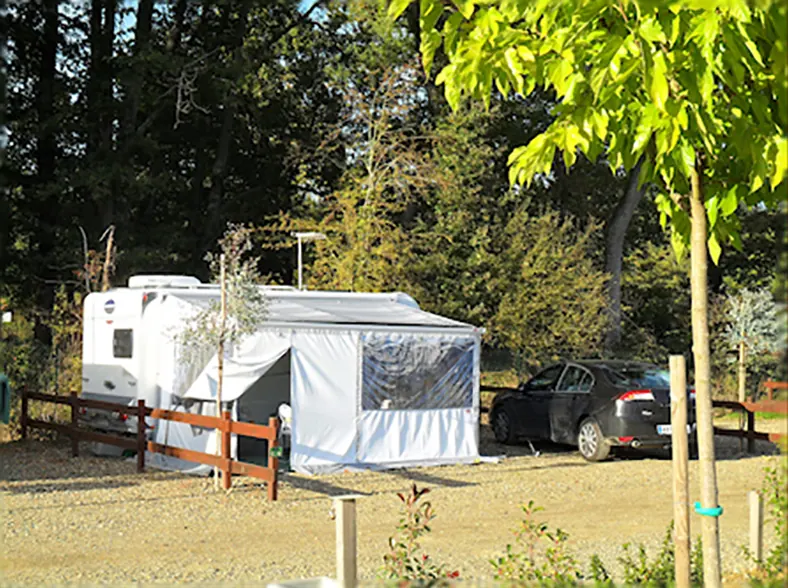Caravane avec auvent sur un emplacement arboré